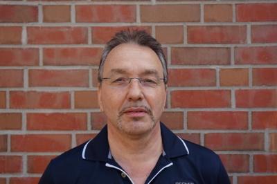 Portraitfoto Jörg Harder vor Mauerwerk