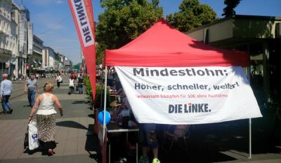Infostand DIE LINKE, Transparent mit der Aufschrift &quot;Mindestlohn - Höher, schneller, weiter!&quot;