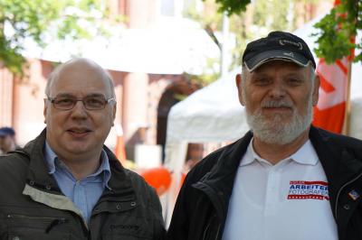 Zwei Personen: André Buschmann und Frank Schlanske, Letzterer im T-Shirt mit der Aufschrift "Arbeiter-Fotografen" und Cappy. Zwei Personen: André Buschmann und Frank Schlanske, Letzterer im T-Shirt mit der Aufschrift "Arbeiter-Fotografen" und Cappy.