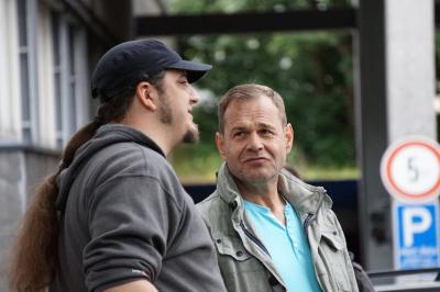 Zwei Männer - Harry Gosch seitlich mit Cappy und langem Zopf, daneben André Grundmann in Jacke und hellblauem T-Shirt Zwei Männer - Harry Gosch seitlich mit Cappy und langem Zopf, daneben André Grundmann in Jacke und hellblauem T-Shirt