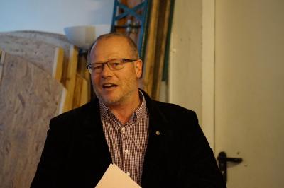 Ein Mann mit Dreitagebart und Brille spricht. Er trägt ein kariertes Hemd und ein schwarzes Sakko. Ein Mann mit Dreitagebart und Brille spricht. Er trägt ein kariertes Hemd und ein schwarzes Sakko.