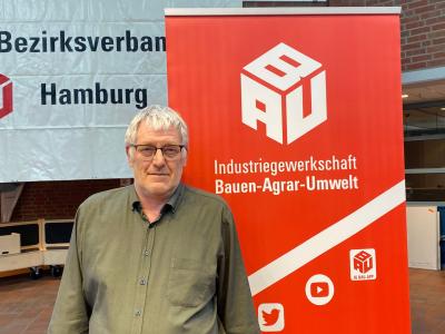Portraitaufnahme Achim Bartels vor einer gemauerten Wand