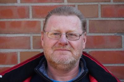 Portraitaufnahme Helge Gutt vor einer gemauerten Wand Portraitaufnahme Helge Gutt vor einer gemauerten Wand