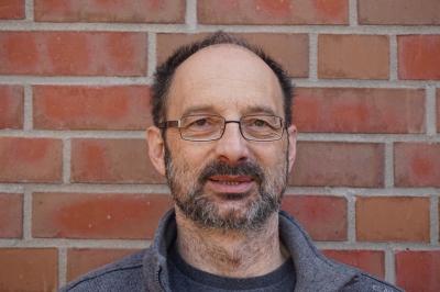 Portraitfoto Bodo Voigt vor einer gemauerten Wand Portraitfoto Bodo Voigt vor einer gemauerten Wand