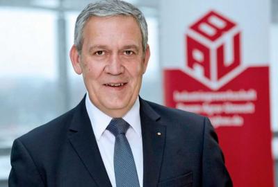 Portrait von Robert Feiger, im Hintergrund das Logo der IG BAU Portrait von Robert Feiger, im Hintergrund das Logo der IG BAU