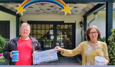 Helge Gutt (links) überreicht einen überdimensionalen Scheck an Christiane Schüddekopf vom Kinderhospiz Sternenbrücke.