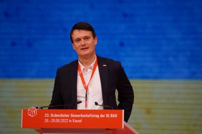 Vasyl Andreyev im schwarzen Jackett, weißem Hemd und mit umgehängtem Teilnehmerausweis an einem roten Band steht am Rednerpult. Im Hintergrund die ukrainischen Nationalfarben blau und gelb. Vasyl Andreyev im schwarzen Jackett, weißem Hemd und mit umgehängtem Teilnehmerausweis an einem roten Band steht am Rednerpult. Im Hintergrund die ukrainischen Nationalfarben blau und gelb.