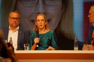 Nicole Siems, in grünem Kleid, am Mikro. Links neben ihr Carsten Burckhardt. Nicole Siems, in grünem Kleid, am Mikro. Links neben ihr Carsten Burckhardt.