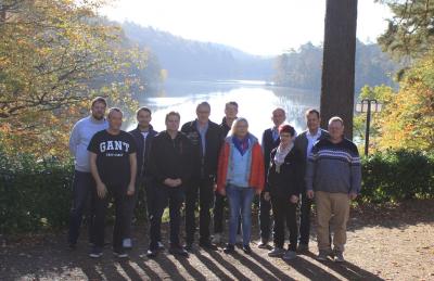 Der zehnköpfige Bezirksvorstand zusammen mit Regionalleiter Grundmann vor dem Hintergrund eines Sees - rundherum Wald.