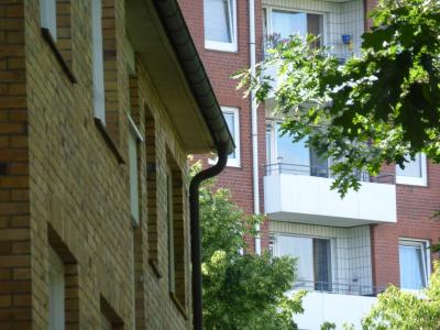 Zwei Geschosswohnungsbauten zwischen Bäumen ... im Vordergrund ein Haus mit gelben Klinkern, im Hintergrund ein höheres Haus mit roten Klinkern und weißen Balkonen. Zwei Geschosswohnungsbauten zwischen Bäumen ... im Vordergrund ein Haus mit gelben Klinkern, im Hintergrund ein höheres Haus mit roten Klinkern und weißen Balkonen.