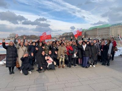 Etwa drei Dutzend Frauen, einige davon mit Flaggen der IG BAU, am Alsteranleger Jungfernstieg.