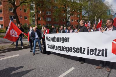 Hamburgs Bürgermeister Peter Tschentscher vor Teilnehmern der Hamburger Mai-Demo 2022. Er blickt sich gerade nach einem Transparent um, auf dem steht: "Hamburger Tariftreuegesetz jetzt!" Hamburgs Bürgermeister Peter Tschentscher vor Teilnehmern der Hamburger Mai-Demo 2022. Er blickt sich gerade nach einem Transparent um, auf dem steht: "Hamburger Tariftreuegesetz jetzt!"