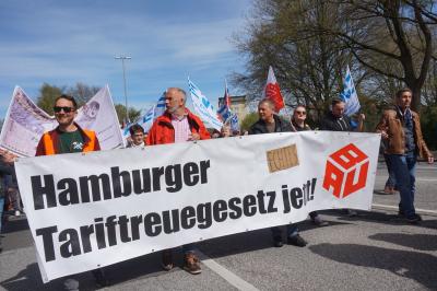 Aktive der IG BAU mit einem Transparent zum Thema Tariftreuegesetz