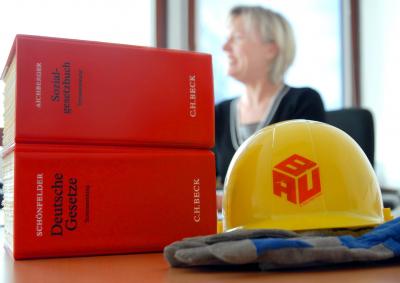 Gesetzesbücher und Bauhelm in einer Kanzlei. Gesetzesbücher und Bauhelm in einer Kanzlei.